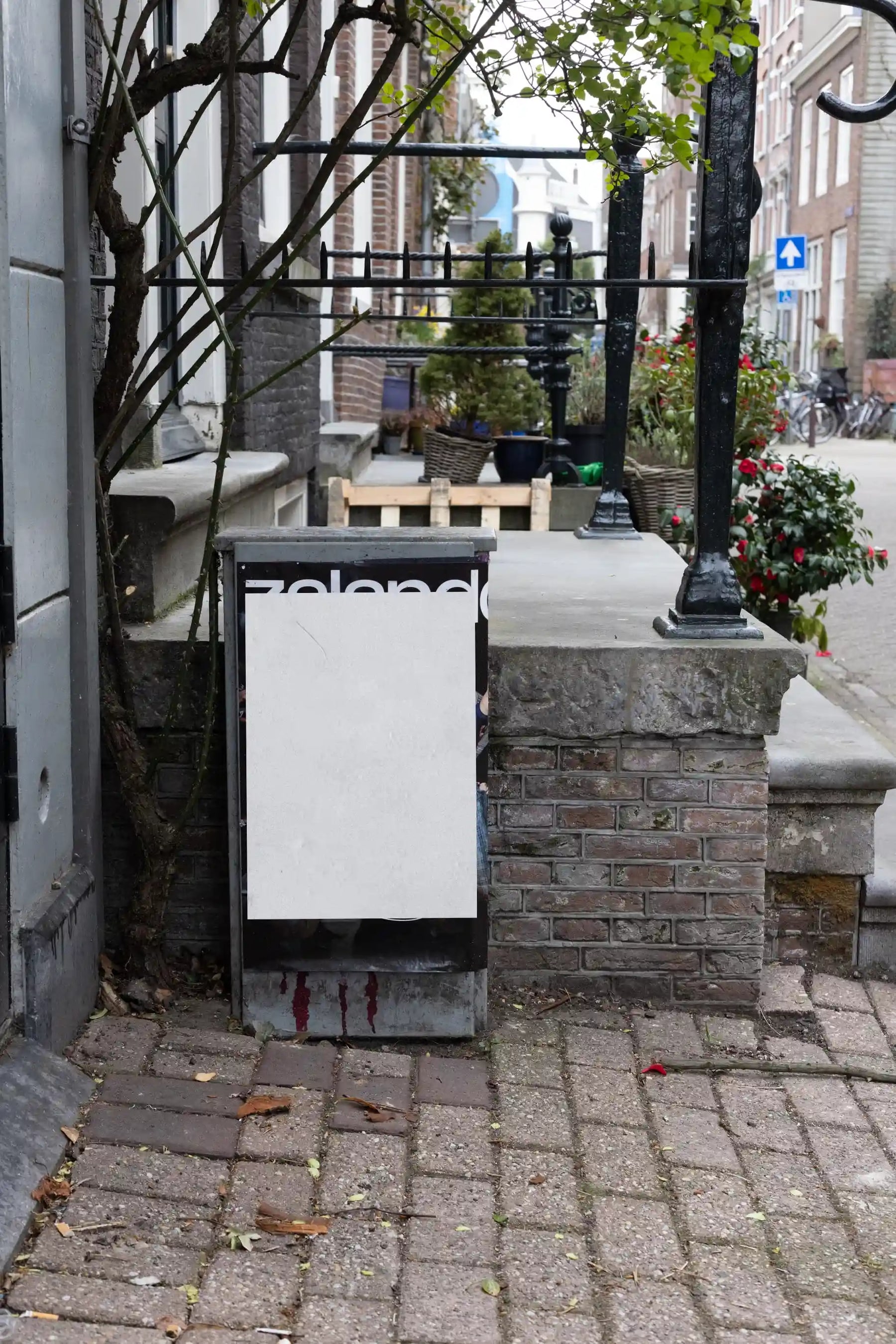 Blank vertical poster mockup on a utility box in a residential street in Amsterdam