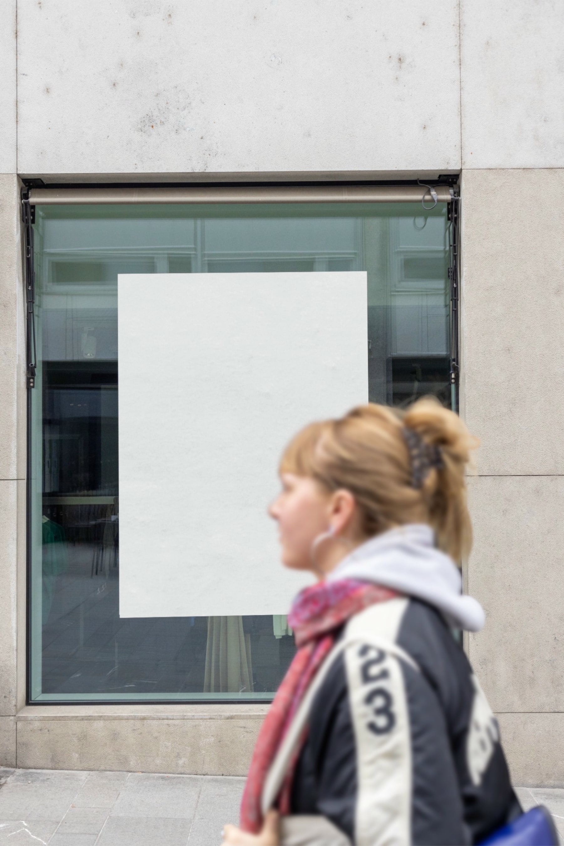 Blank vertical window poster in Basel with a woman walking across the lower right foreground